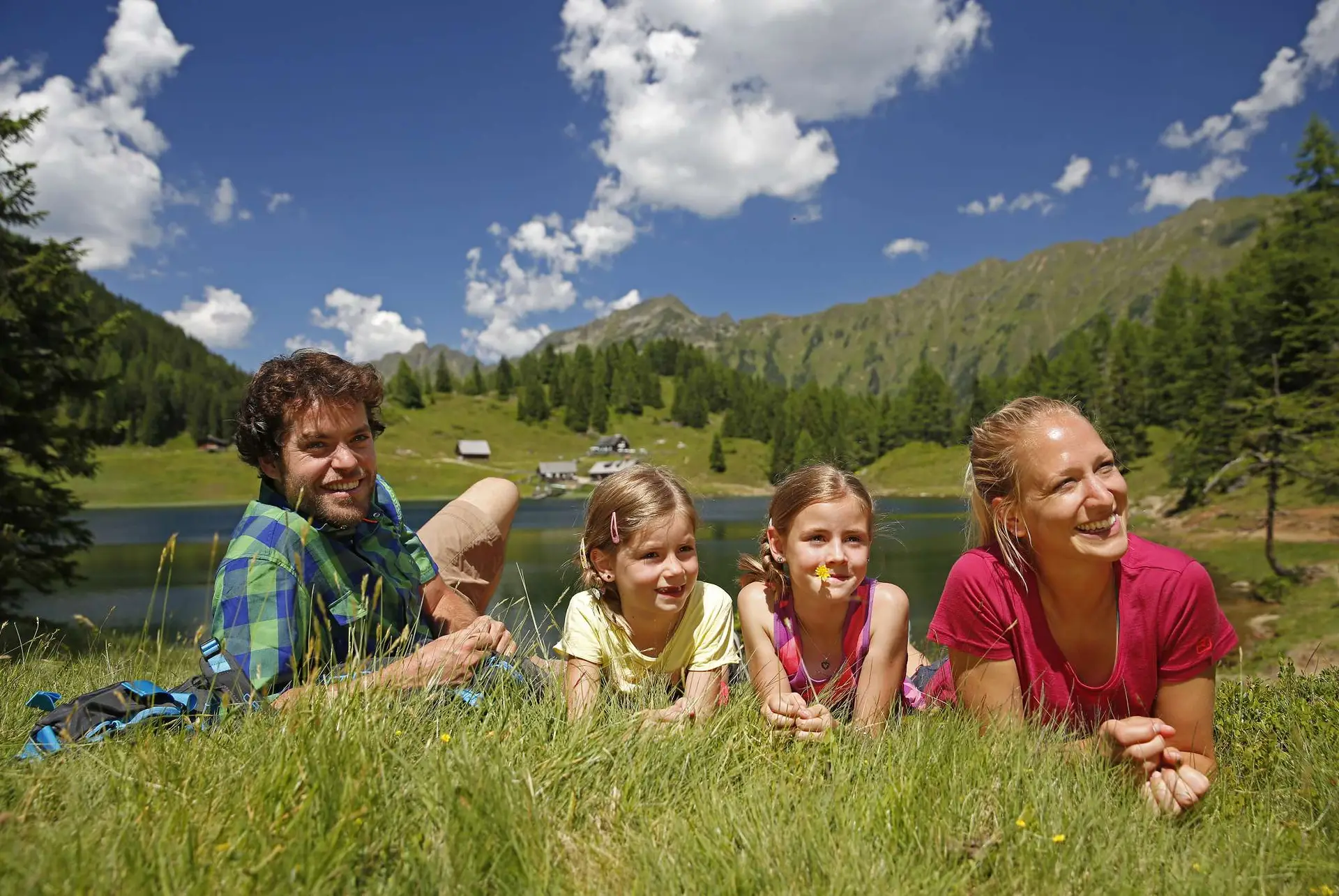 Eine Familie liegt in der Nähe eines Sees in Ramsau am Dachstein.